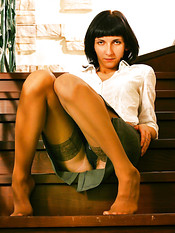 Upskirts amateur in beige stockings sits on the stairs